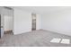Open bedroom features carpet, ample natural light, and access to a bathroom, providing a comfortable living space at 47771 W Mellen Ln, Maricopa, AZ 85139
