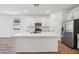 Modern kitchen featuring a central island, sleek white cabinetry, and stainless steel appliances at 47771 W Mellen Ln, Maricopa, AZ 85139
