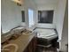 Bathroom with double sinks, a large soaking tub, and wood cabinets at 51989 W Esch Trl, Maricopa, AZ 85139