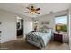 Guest bedroom with a metal bed frame, carpet flooring, and access to a bathroom at 5296 S Sugarberry Ct, Gilbert, AZ 85298