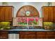 Kitchen sink with granite countertop and arched window at 5296 S Sugarberry Ct, Gilbert, AZ 85298