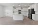 Bright kitchen featuring white cabinets, stainless appliances, a kitchen island, and an open floor plan at 7416 S 76Th Ln, Laveen, AZ 85339