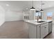 An open concept with a kitchen island looking into a living space and sliding glass doors at 7416 S 76Th Ln, Laveen, AZ 85339