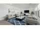 A staged living room with modern decor, a patterned rug, and large screen television at 7416 S 76Th Ln, Laveen, AZ 85339