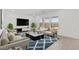 A staged living room with modern decor, a patterned rug, and large screen television at 7416 S 76Th Ln, Laveen, AZ 85339