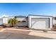 Single-wide manufactured home with attached garage and palm tree landscaping at 747 E Germann Rd # 67, San Tan Valley, AZ 85140