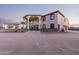 Two-story house with stucco exterior, large windows, and a porte-cochere, plus a three car garage at 8315 E Palm Ln, Mesa, AZ 85207