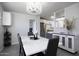 Bright dining room with white table, gray chairs and view into kitchen at 8547 W Magnum Dr, Arizona City, AZ 85123