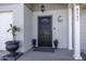 Front entrance with black door, security screen, and decorative planters at 8547 W Magnum Dr, Arizona City, AZ 85123