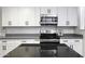 Modern kitchen with white cabinets, black countertops and stainless steel appliances at 8547 W Magnum Dr, Arizona City, AZ 85123