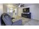 Living room with gray sectional, TV, fireplace, and access to kitchen at 8547 W Magnum Dr, Arizona City, AZ 85123