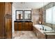 Elegant bathroom with double sinks, a soaking tub and walk-in shower at 10484 E Mission Ln, Scottsdale, AZ 85258