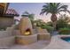 Outdoor fireplace with built-in seating at 10484 E Mission Ln, Scottsdale, AZ 85258