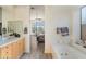 Main bathroom with a bathtub, double vanity, and views into the bedroom at 11453 E Mark Ln, Scottsdale, AZ 85262