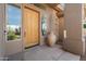 Inviting front entry with wood door, large planter, and sidelights at 11453 E Mark Ln, Scottsdale, AZ 85262