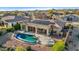 Aerial view of a kidney-shaped pool, patio furniture, and solar panels at 11453 E Mark Ln, Scottsdale, AZ 85262