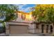 Two-story house with tan exterior, landscaped yard, and two-car garage at 1174 E Canyon Creek Dr, Gilbert, AZ 85295