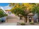 Two-story house with tan exterior, landscaped yard, and two-car garage at 1174 E Canyon Creek Dr, Gilbert, AZ 85295