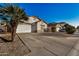 House with a driveway, palm tree, and neighboring homes at 12810 W Edgemont Ave, Avondale, AZ 85392