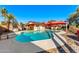 Kidney-shaped pool surrounded by a rock border and a red shade sail at 13601 N 50Th Pl, Scottsdale, AZ 85254