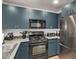 Modern kitchen with stainless steel appliances and dark teal cabinets at 16 W Encanto Blvd # 409, Phoenix, AZ 85003