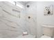 Clean bathroom with marble shower, recessed shelving, and toilet at 1722 Leisure World --, Mesa, AZ 85206