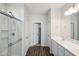 Clean bathroom with white vanity, glass shower, and dark wood-look tile floor at 17852 W Country Club Ter, Surprise, AZ 85387