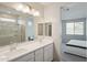 Main bathroom with double sinks and a view of the bedroom at 17852 W Country Club Ter, Surprise, AZ 85387