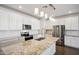 Bright kitchen with granite island, white cabinets, and stainless steel appliances at 17852 W Country Club Ter, Surprise, AZ 85387