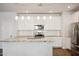 Modern kitchen with granite island, white cabinets, and stainless steel appliances at 17852 W Country Club Ter, Surprise, AZ 85387