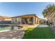 Backyard featuring a sparkling pool, artificial grass, and a covered patio for outdoor relaxation at 1814 W Desert Spring Way, San Tan Valley, AZ 85144