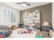 Neutral-toned bedroom features large window, ceiling fan, and ample storage with shelves at 1814 W Desert Spring Way, San Tan Valley, AZ 85144