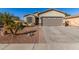 Front of home with a well-manicured lawn, stone accents, and three car garage at 1814 W Desert Spring Way, San Tan Valley, AZ 85144