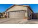 Attached garage featuring a multi-paneled door, stone accents, and exterior lighting at 1814 W Desert Spring Way, San Tan Valley, AZ 85144