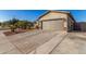 Attached garage featuring a multi-paneled door, stone accents, and exterior lighting at 1814 W Desert Spring Way, San Tan Valley, AZ 85144