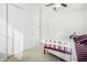 Well-lit bedroom with twin bed, ceiling fan, and spacious closet at 2114 W Red Fox Rd, Phoenix, AZ 85085