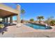 Relaxing pool area with a covered patio and palm trees at 22155 N Cline Ct, Maricopa, AZ 85138