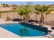 Stunning pool with a stone feature wall, overlooking a golf course at 22155 N Cline Ct, Maricopa, AZ 85138