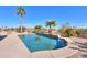 Inviting kidney-shaped pool with a stone feature and palm trees at 22155 N Cline Ct, Maricopa, AZ 85138