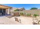 A backyard featuring a paved patio, a built-in grill, and a garden with various plants and flowers at 36248 W Cartegna Ln, Maricopa, AZ 85138