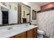 Bathroom with double sinks, a decorative mirror, and a shower at 36248 W Cartegna Ln, Maricopa, AZ 85138