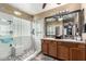 Large bathroom with double sinks, glass shower, and stone floor at 36248 W Cartegna Ln, Maricopa, AZ 85138