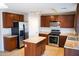 Kitchen with dark wood cabinets, stainless steel appliances, and island at 36285 N Mirandesa Dr, San Tan Valley, AZ 85143