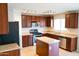 Kitchen with dark wood cabinets, stainless steel appliances, and island at 36285 N Mirandesa Dr, San Tan Valley, AZ 85143