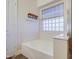 Relaxing bathroom with a large bathtub and a glass block window for natural light at 4710 E Torrey Pines Ln, Chandler, AZ 85249