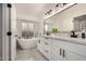 Modern bathroom with double sinks, a soaking tub, and a large mirror at 5402 E Paradise Ln, Scottsdale, AZ 85254