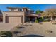 Tan two-story house with a two-car garage and desert landscaping at 5432 E Grandview Rd, Scottsdale, AZ 85254