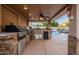 Outdoor kitchen with pool view, grill, and seating area at 5432 E Grandview Rd, Scottsdale, AZ 85254