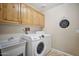 Laundry room with wood cabinets, a sink, and a washer and dryer at 5819 S 102Nd Dr, Tolleson, AZ 85353