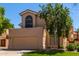 Two-story house with tan exterior, attached garage, and landscaped lawn at 6439 E Redmont Dr, Mesa, AZ 85215